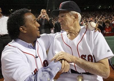 Former Boston Red Sox pitcher Pedro Martinez hugs former Red Sox player Johnny Pesky after Martinez threw out the ceremonial first pitch before the opener. (AP)