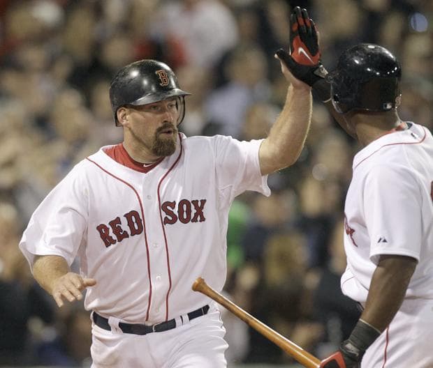 Red Sox&#39;s Kevin Youkilis is congratulated by Adrian Beltre after scoring on a passed ball in the seventh inning against the New York Yankees during the opening game of the season on Sunday, in Boston. (AP)