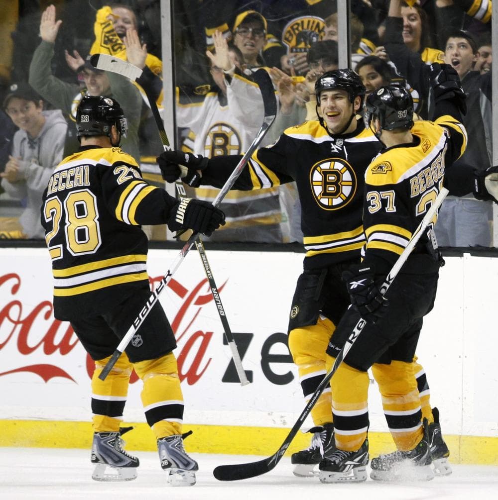Boston Bruins' Milan Lucic, center, celebrates his empty-net goal with teammates Mark Recchi (28) and Patrice Bergeron (37) during the third period against the Carolina Hurricanes, Saturday.(AP Photo/Michael Dwyer)