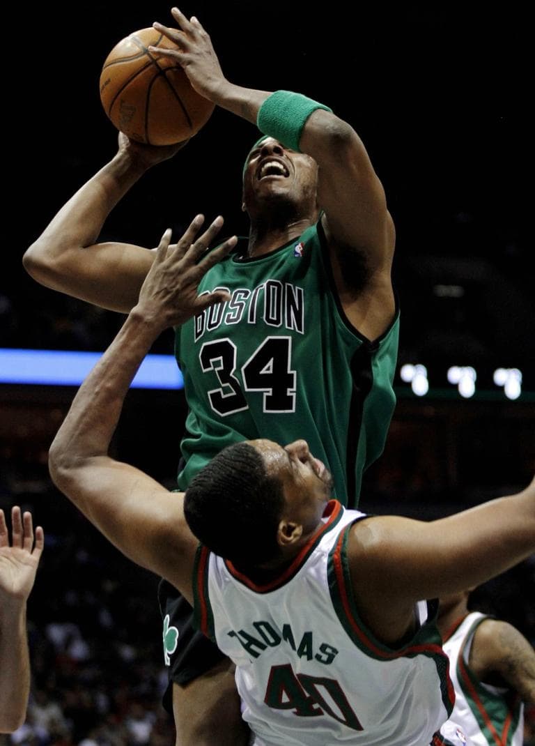 Boston Celtics' Paul Pierce,  is charged with a offensive foul against Milwaukee Bucks' Kurt Thomas, front, in the first half  Saturday.(AP Photo/Darren Hauck)