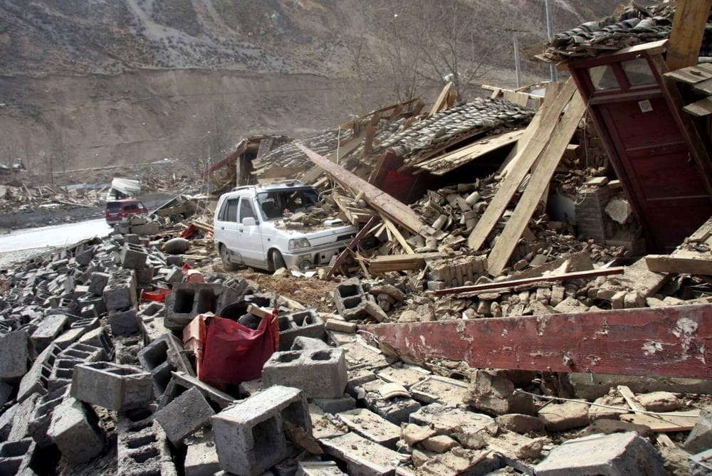 A car is buried under the rubble after an earthquake in Yushu County, northwest China&#39;s Qinghai Province on Wednesday. (AP Photo/Xinhua, Ren Xiaogang) 