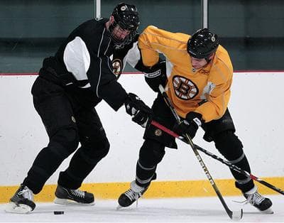 Boston Bruin defenseman Zdeno Chara, left, tries to keep teammate Milan Lucic away from the puck during a practice in Wilmington on Tuesday. The Bruins will face the Buffalo Sabres in the first round of the NHL playoffs. (AP)