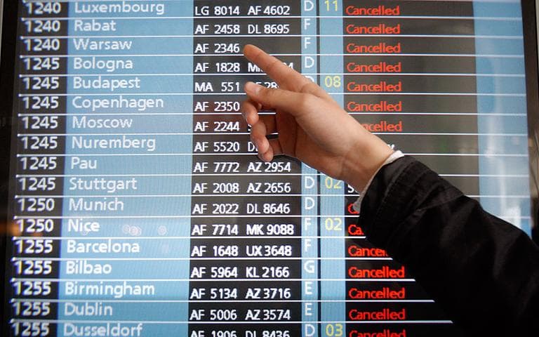 A passenger points to a flight information screen at Roissy Charles de Gaulle Airport on Friday. The Icelandic volcano that erupted Wednesday has sent an enormous cloud of microscopic ash particles across northern Europe, grounding aircraft across the continent. (AP)