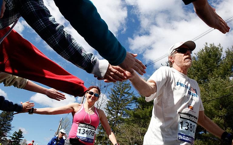 Timothy Hann, of Tempe, Arizona, right, and Lisa Plante, of Brookline, reach out to spectators near the start of the Boston Marathon in Hopkinton. (AP) (Click to enlarge)