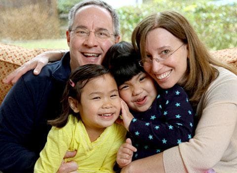 Bethany and Kevin Durkin hold their daughters Olivia, 7, left, and Lucy, 5, in their in Katonah, N.Y. home. The Durkins are part of a growing number of parents who have adopted special-needs children from China. March 13, 2010. (AP)