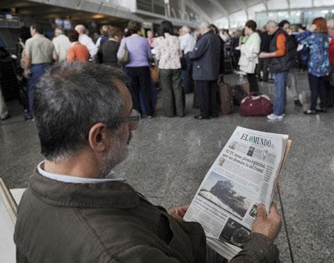 A passenger reads a Spanish newspaper showing a picture on the front page of the Icelandic volcano eruption, as he waits at Bilbao airport, April 18, 2010. The airport was closed due to a cloud of volcanic ash emanating from a volcanic eruption in Iceland. (AP)