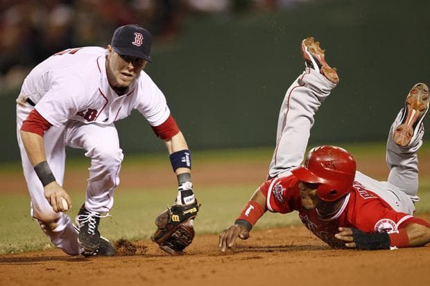 Boston second baseman Dustin Pedroia looks to throw to first to complete a double play after tagging out Los Angeles' Erick Aybar during the eighth inning of the game in Boston on Tuesday. (AP)