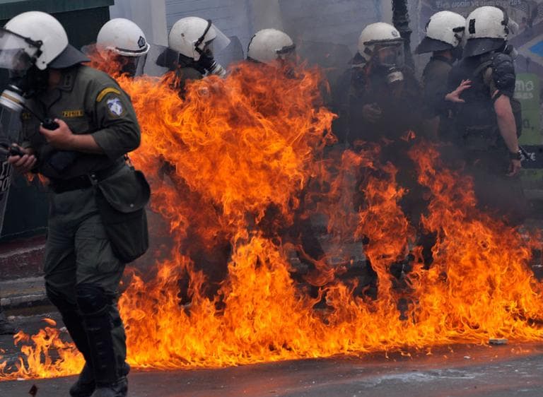 A petrol bomb explodes next to riot police in central Athens, on Wednesday. (AP) (Click to enlarge)