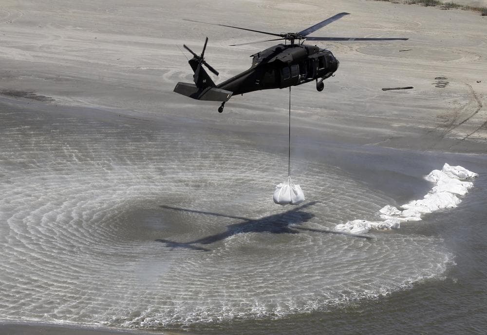 A Blackhawk helicopter prepares to drop sandbags in their efforts to dam off part of the marsh on Elmer&#039;s Island in Grand Isle, La.  (AP) 