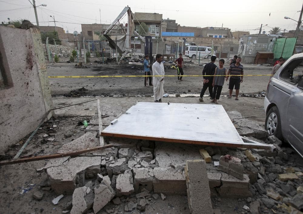 People inspect the site of a car bomb attack in Baghdad, Iraq. A car bomb ripped through a popular cafe on Wednesday evening, killing nine young people.(AP)