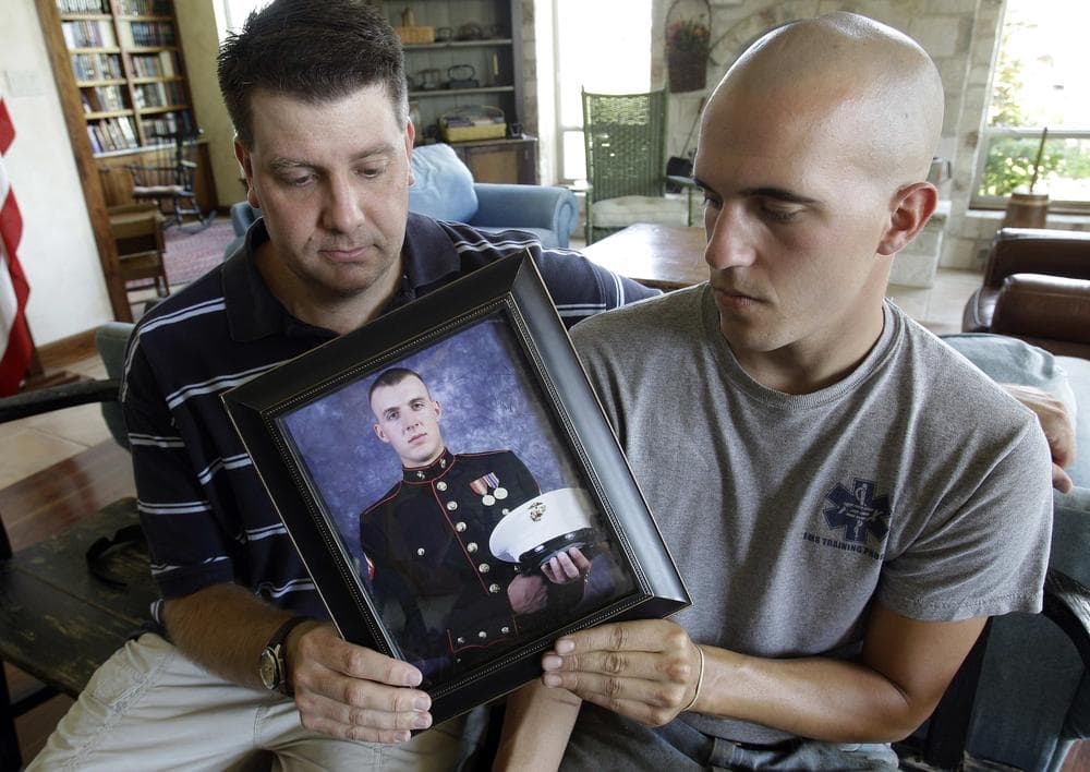 Jonathan Leicht, left, and Jesse Leicht, right, pose with a photo of their brother, Marine Cpl. Jacob Leicht. (AP Photo/Eric Gay)