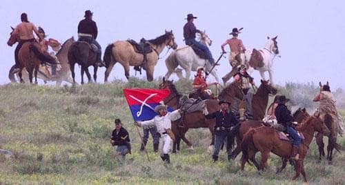 George Armstrong Custer (played by Tony Austin) stands with his flag surrounded by cavalry and warriors before his death Friday, June 26, 1998, during Custer&#039;s Last Stand Reenactment in Hardin, Mt. (AP)