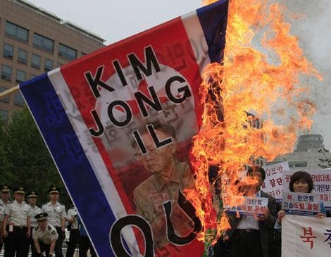 South Korean activists burn a North Korean flag with a picture of North Korean leader Kim Jong Il during a rally in South Korea, May 25, 2010. (AP)