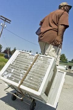 A Washington state man wheels his air conditioner out of storage during 100 degree temperatures in 2008. (AP)