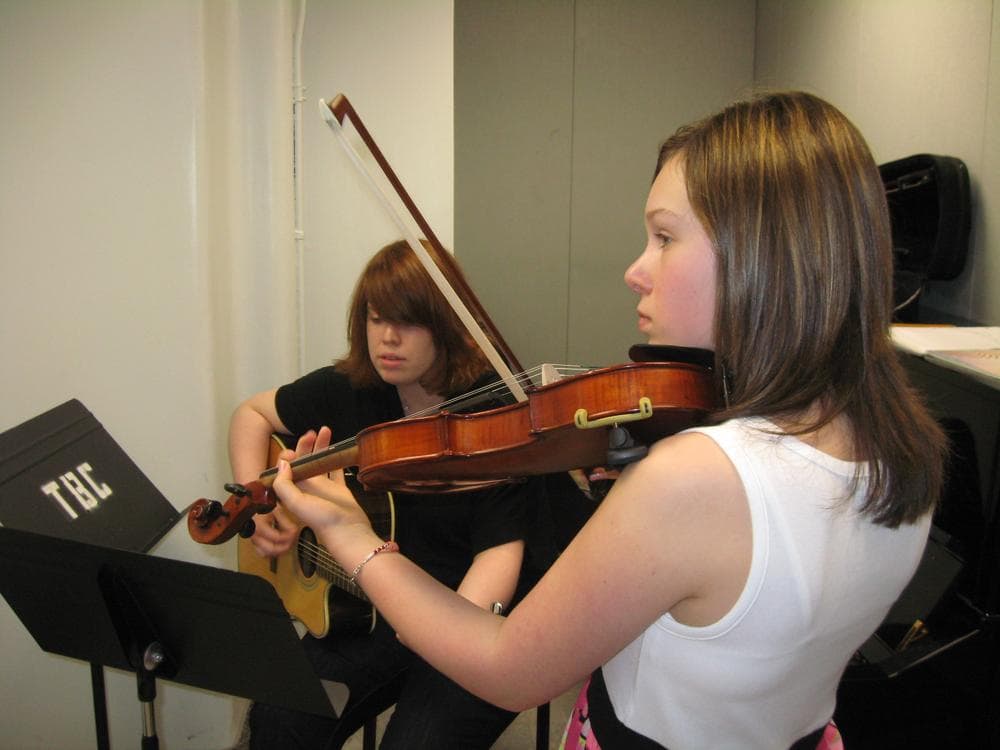 Lindsey Melo, 12, plays violin at the Boston Conservatory while accompanied on guitar by her instructor, Kristy Foye. (Sacha Pfeiffer/WBUR)