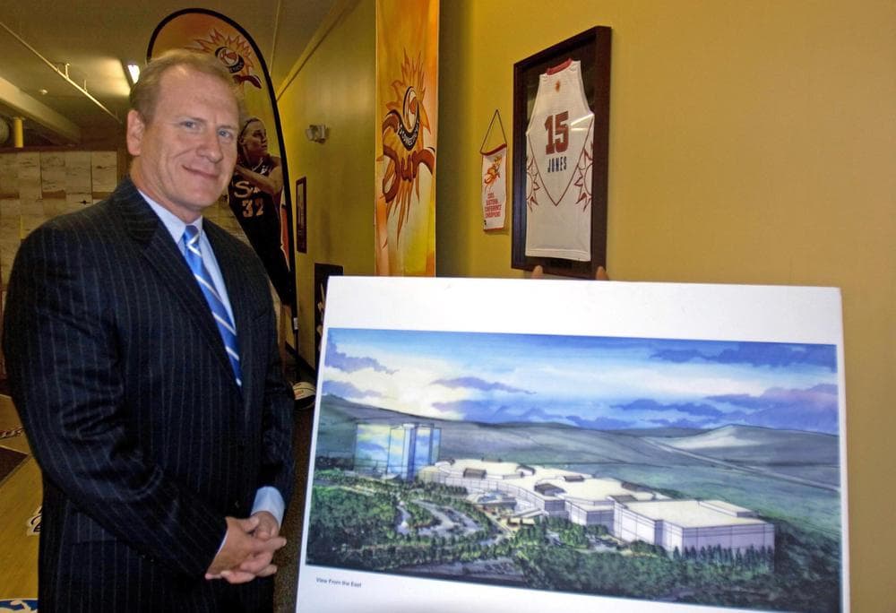 Jeff Hartmann, chief operating officer at Mohegan Sun, stands beside a rendering of a planned resort casino in Palmer. Mohegan Sun has an office in town and is already leasing the land it would build the casino on if state lawmakers approve gambling in the state and Mohegan Sun receives one of the licenses. (Lisa Tobin/WBUR)