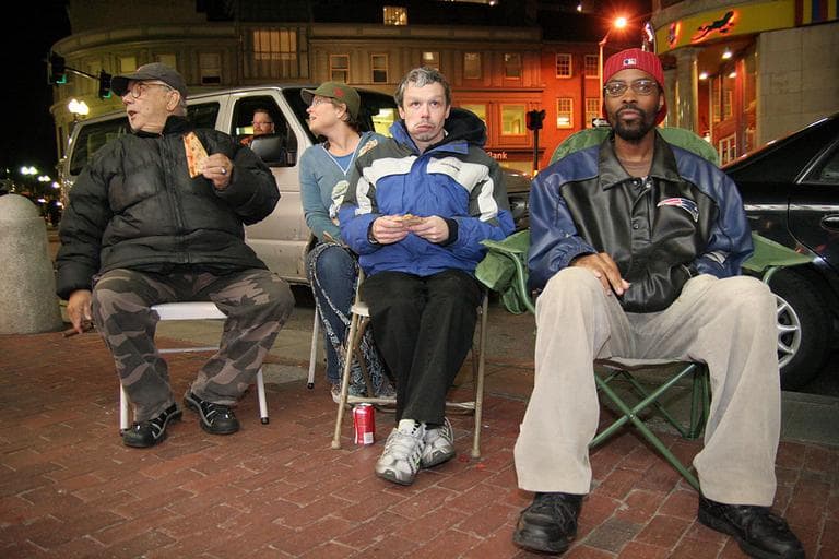 A group of regulars set up chairs outside Cardullo's in Harvard Square to watch Red Sox game through the window on the shop's flat screen TV.  (Andrew Phelps/WBUR) 