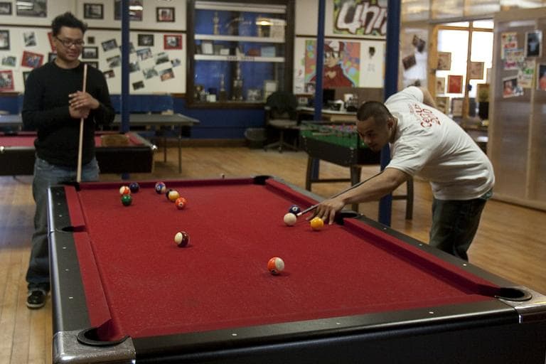 Johnny and Ricky play pool at the United Teen Equality Center in Lowell. (Jess Bidgood for WBUR)
