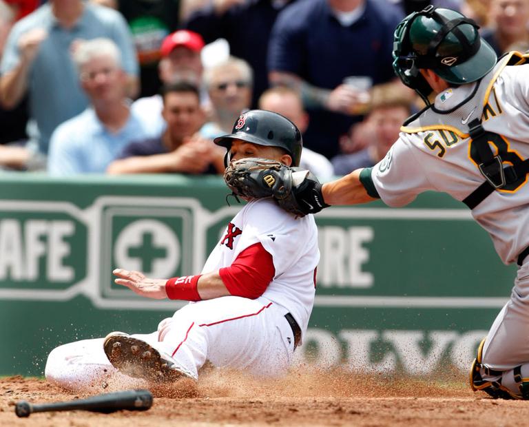 Boston Red Sox's Victor Martinez is out at home while attempting to score on a double hit by Red Sox's Kevin Youkilis as Oakland Athletics' catcher Kurt Suzuki makes the play in the third inning from Fenway Park on Thursday. (AP)