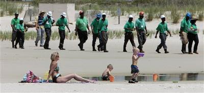  Mary Smith of Theodore, Ala., watches over her grandchildren as a large crew of clean up workers walk along the beach in Dauphin Island, Ala.(AP)