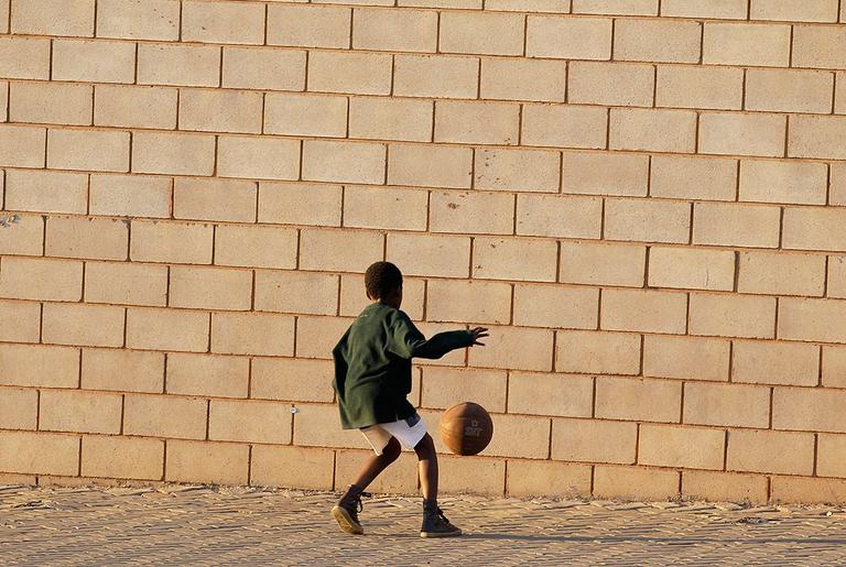 A boy kicks a ball in front of the Super Stadium in Atteridgeville, near Pretoria, South Africa, on Tuesday. The World Cup kicks off for the first time on the continent on Friday. (AP)