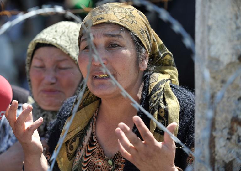 An Uzbek woman who fled from the southern Kyrgyz city of Osh after her husband was killed and house burned down stands in line near the Uzbek village of Jalal-Kuduk waiting for permission to cross into Uzbekistan, on Monday. (AP)