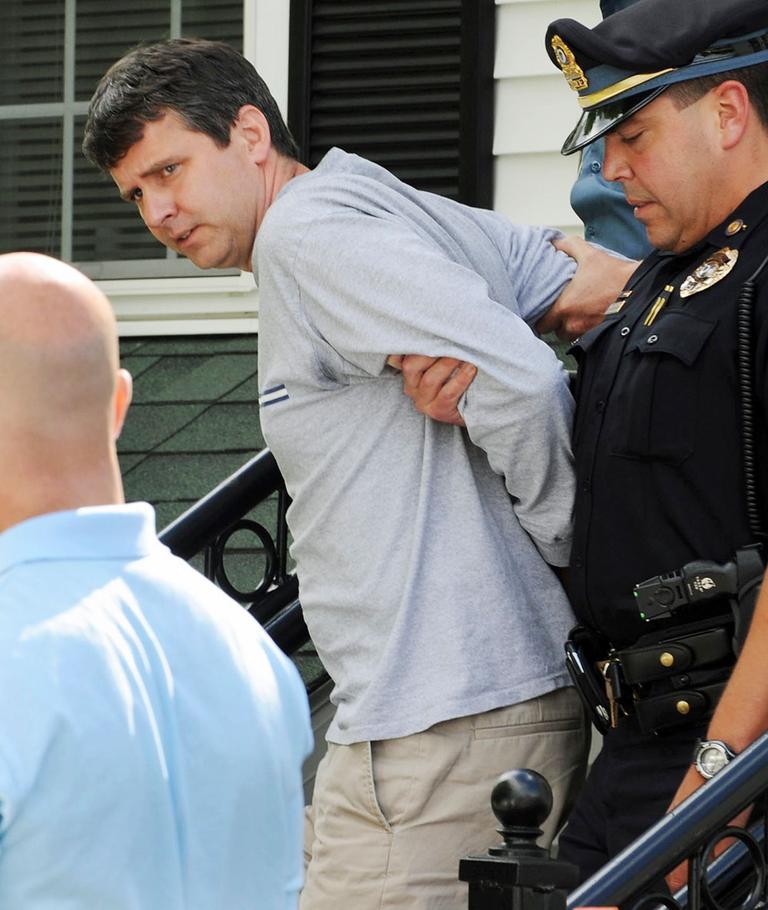 Thomas Mortimer IV is led from the police station by Police Chief James Palmeri after he was arrested Thursday in Bernardston. (AP)
