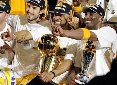 Los Angeles Lakers guard Derek Fisher, center, holds the Larry O&#039;Brien Trophy as Kobe Bryant, right, holds the MVP trophy as they celebrate after beating the Boston Celtics, 83-79, in Game 7 of the NBA basketball finals. (AP)