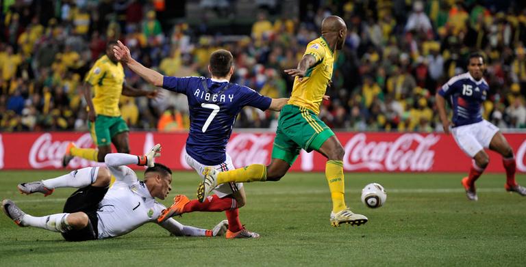 France&#39;s Franck Ribery, center, crosses the ball to Florent Malouda, right, to score a goal during a match against South Africa on Tuesday. France lost though, 2-1, and was ousted from the World Cup. (AP)
