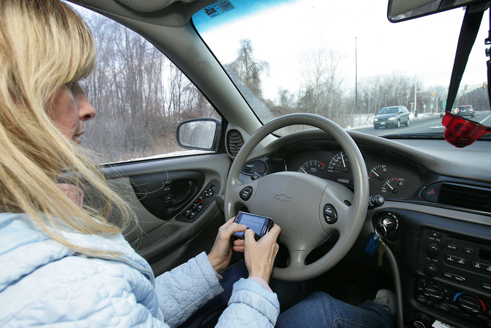 In this December 2009 file photo, Tina Derby sends text messages while driving in Concord, New Hampshire. (Jim Cole/AP)