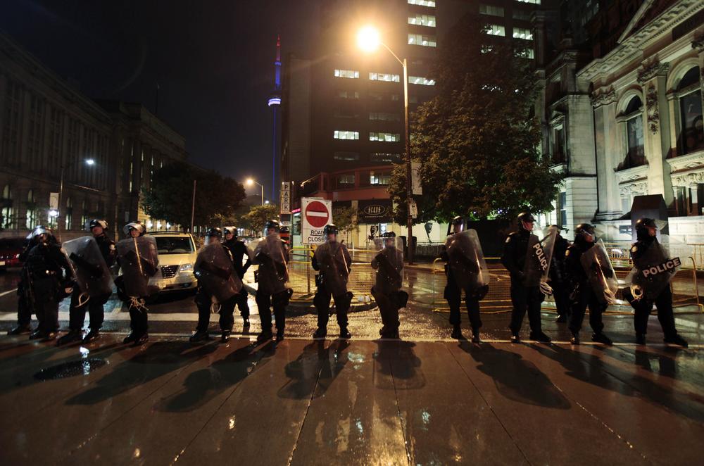 Canadian police officers form a line to prevent demonstrators from near the fence that surrounds the G-20 global economic summit in downtown Toronto, Canada, late Saturday.  (AP Photo/Lefteris Pitarakis)