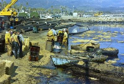In this 1969 picture, workers use straw to absorb oil from the beach at Santa Barbara Harbor, Calif. The oil which leaked from an offshore well, covered local beaches and threatened many southern California shoreline areas. The incident at the Union Oil Co. platform helped lead to the Clean Water Act. (AP)