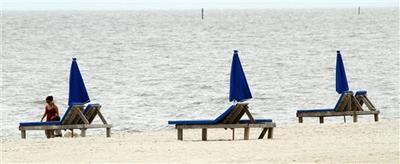 Unoccupied umbrellas and lounges along the beach in Biloxi, Miss. (AP )