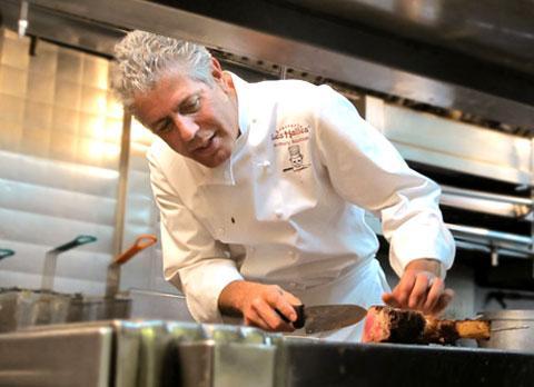 Anthony Bourdain in his show &quot;No Reservations&quot; cutting steak. (Credit: TravelChannel.com)