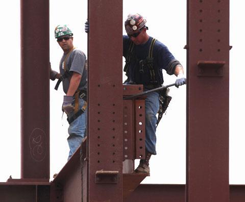 Construction workers guide a steal beam into place on a building in Philadelphia, April 27, 2010 (AP)