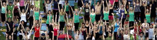 Thousands of people take a yoga class from acclaimed yogi, Elena Brower on the great lawn of Central Park, June 22, 2010 in New York. (AP)