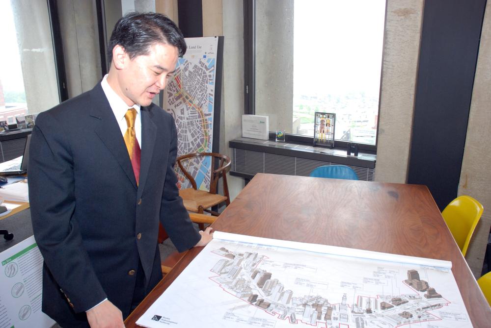 Kairos Shen, Boston's chief city planner, looks at plans for the Greenway in his City Hall office. (Lisa Tobin/WBUR)