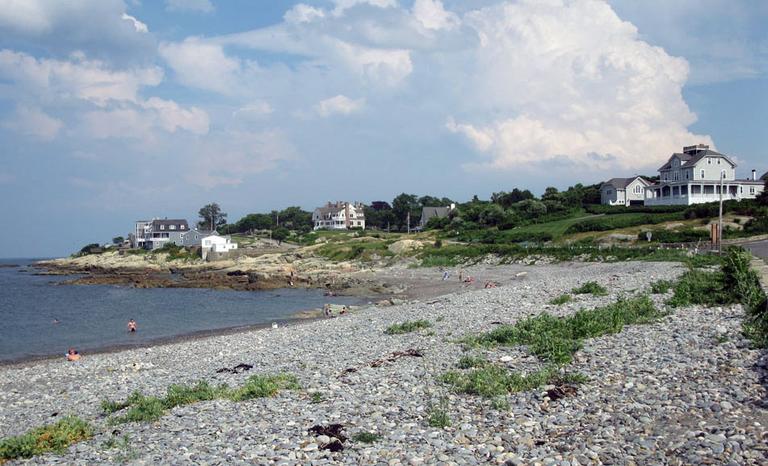 Houses overlook a pebbled beach in Cohasset. (Fred Thys/WBUR)