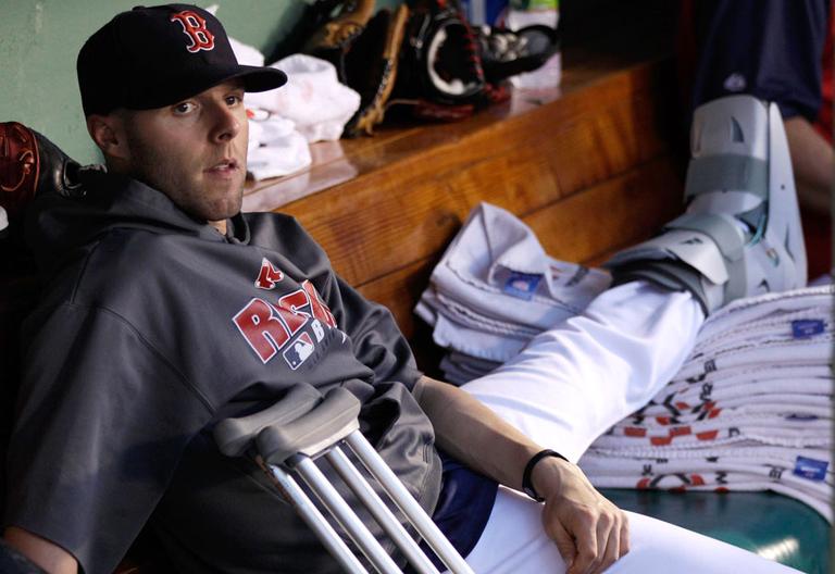 Boston Red Sox second baseman Dustin Pedroia rests his broken left foot in the dugout during a game on July 2. Pedroia says his foot doesn't require surgery and he hopes to return to the lineup soon. (AP)