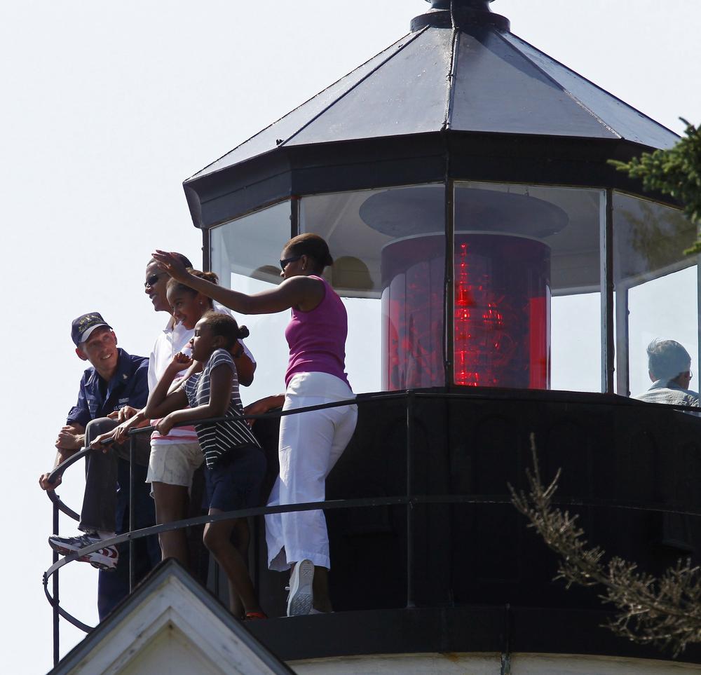 President Obama, first lady Michelle Obama, right, and daughters Malia and Sasha, center right, stand with Coast Guard Station chief Tim Chase, left, as they visit Bass Harbor Head Lighthouse in Bar Harbor, Maine, Saturday. (AP Photo/Charles Dharapak)