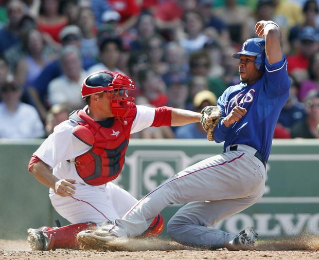 Texas' Elvis Andrus is safe at home plate as Boston's Kevin Cash puts the tag on in the eighth inning of the game on Sunday in Boston. The Rangers won 4-2. (AP)