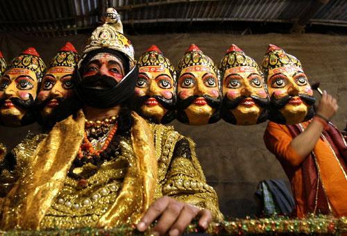 An artist wearing a mask of demon king Ravana waits to perform at a Ramleela, a theater based on the Ramayana in Mumbai, India, Sunday, Sept. 27, 2009. (AP)