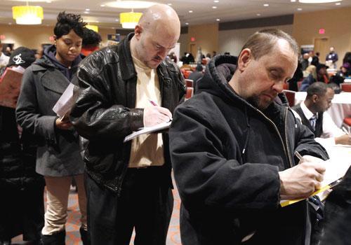 Detroit residents fill out applications while attending a job fair, Feb. 2010. (AP)