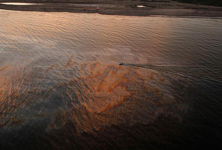 A boat motors through oil sheen from the Deepwater Horizon oil spill at sunset off East Grand Terre Island, where the Gulf of Mexico meets Barataria Bay, on the Louisiana coast, on Saturday. (AP)