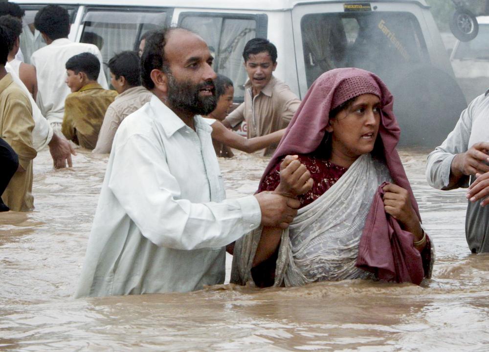 Pakistani villagers evacuate a flooded village near Nowshera,  Pakistan.(AP)