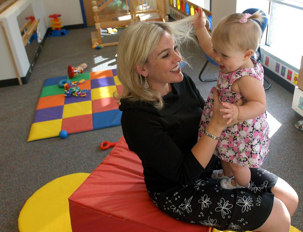 Kirstie Foster, a corporate public relations manager at General Mills, pays a visit to her 10-month-old daughter, Mia, in the daycare facility at the company's headquarters in Golden Valley, Minn. (Ann Heisenfelt/AP)