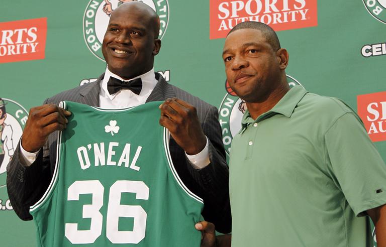 Boston Celtics head coach Doc Rivers, right, presents newly signed Shaquille O'Neal his jersey at a news conference on Tuesday in Waltham.  (AP)
