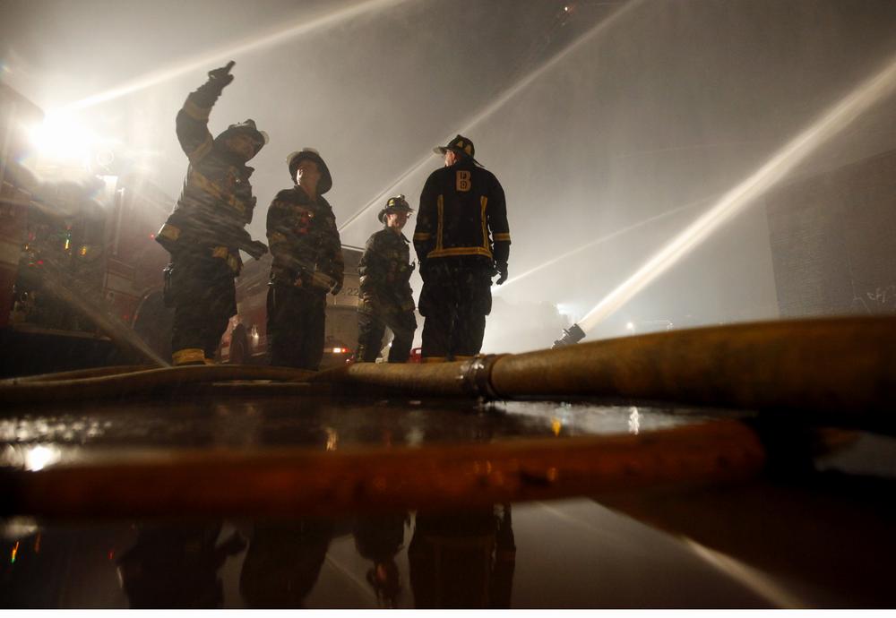 Firefighters man hoses directed at a warehouse in an abandoned industrial complex in Roxbury Saturday night. (AP)