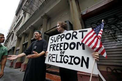 Abdul Malik, center, an American Muslim from Philadelphia, and Matt Sky, right, a Web developer from Manhattan stand in front of a proposed site for an Islamic cultural center in New York. (AP)