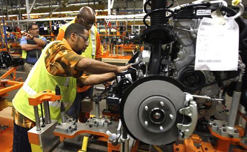 Ford’s Tobias Haliburton works on a 2012 Ford Focus engine at the Michigan Assembly Plant in Wayne, Mich., July 22, 2010. (AP)